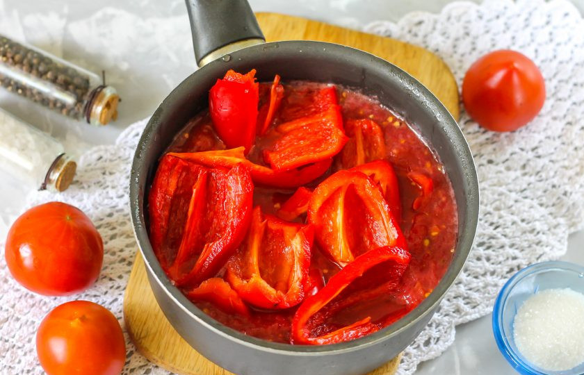 1. Этап. Ленивое лечо: Очистите болгарский перец от семян, срезав крышечки. Промойте овощи и нарежьте четвертинками или пополам. Перелейте томатную массу в казан или ковш, добавьте туда же нарезку перца.