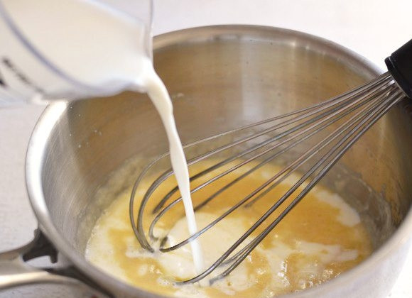 1. Этап. Сырный соус за 5 минут: 3. К золотистой массе в сотейник влейте тонкой струйкой молоко, все время перемешивая венчиком.