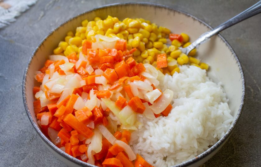 1. Этап. Перец фаршированный рисом и сыром: Добавьте обжаренные овощи к рису с кукурузой.