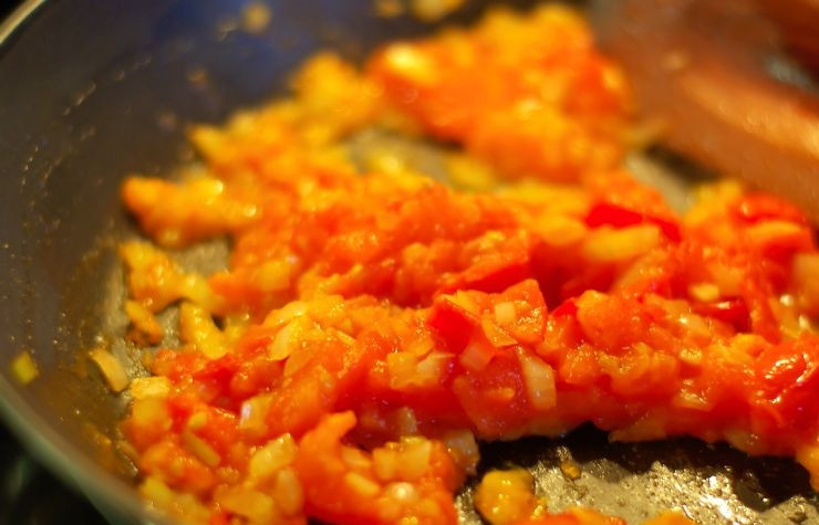 1. Этап. Яичница с помидорами: Затем в сковородку наливаем оливковое масло и добавляем мелко нарезанный лук, немного обжариваем, перемешивая. Затем добавляем мелко нарезанные помидоры. Обжариваем до тем пор, пока не выкипит практически весь помидорный сок.