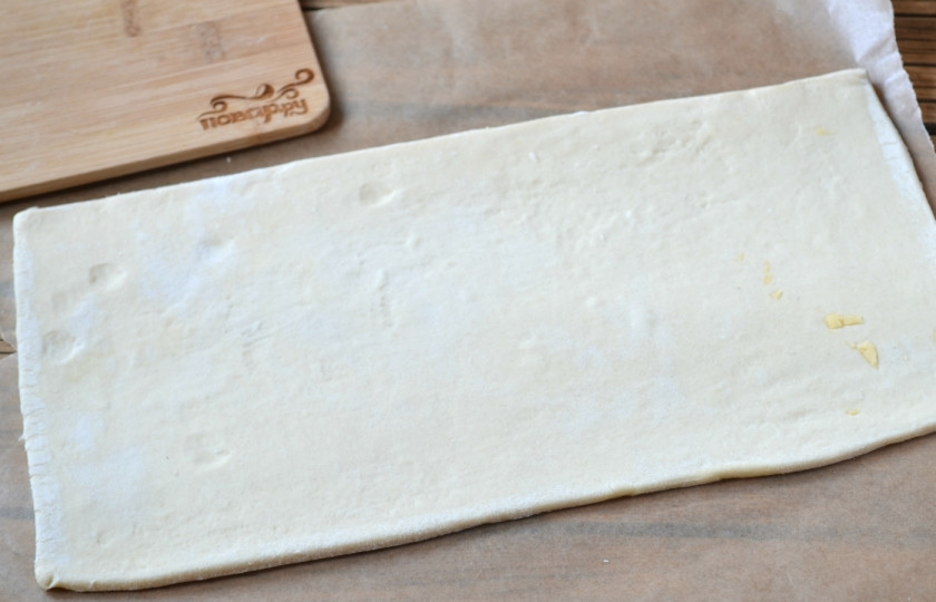 1. Этап. Пирог из слоеного теста с сыром: Один прямоугольник теста слегка раскатайте.