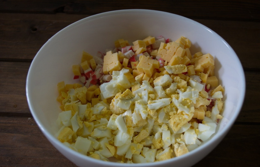 1. Этап. Салат на торжество: Нарежьте кубиком сыр и отварные яйца.