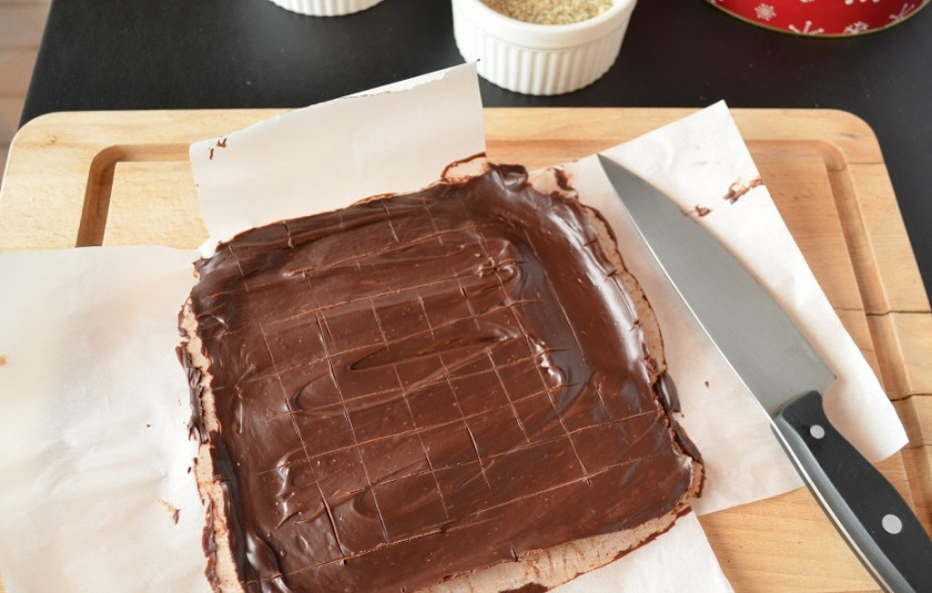 1. Этап. Шоколадные трюфели: 1. Приготовьте два больших листа пергаментной бумаги, сложите крест накрест и сбрызните маслом. Весь шоколад растопите на водяной бане или в микроволновке так, чтобы не осталось комочков. Сливки слегка прогрейте, добавьте сироп, ванилин и мелкую соль, перемешайте. Вылейте сливки на растопленный шоколад, затем введите масло. Перемешайте. Вылейте смесь на приготовленную бумагу. Пусть остынет при комнатной температуре в течение двух часов, затем отправьте еще на два часа в холодильник.