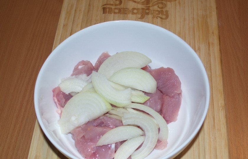 1. Этап. Куриное филе кусочками в духовке: Добавьте нарезанный полукольцами репчатый лук. Помните лук руками, чтоб он распался на полукольца.