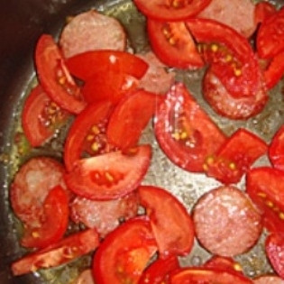 1. Этап. Омлет в мультиварке: Порежьте помидоры небольшими дольками и добавьте к колбасе.