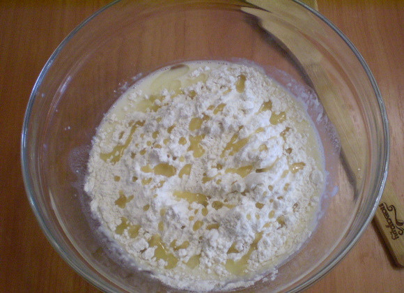 1. Этап. Дрожжевые оладьи на кефире: Всыпаем муку, добавляем масло.