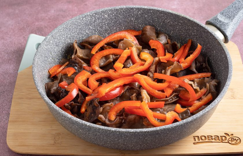 1. Этап. Древесные грибы по-корейски: Добавьте болгарский перец и грибы, обжарьте все вместе еще 2-3 минуты.