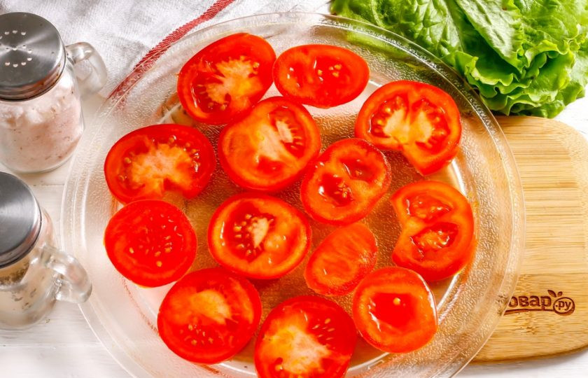 1. Этап. Вяленые помидоры в микроволновке: Помидоры промойте в воде, удалите хвостики с томатов и нарежьте их кружочками. Выложите нарезку на поддон микроволновки, смазывать поддон ничем не нужно. Лучше всего использовать овощи не сочных сортов, чтобы в них было больше мякоти и меньше жидкости. Поместите поддон в микроволновку на 2 минуты, включите технику на полную мощность.